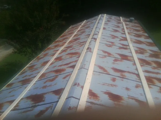 Rusted metal roof panels with new wood purlins before replacement — Storm Damage Roof Repair in Hollsopple by Roofing Brothers