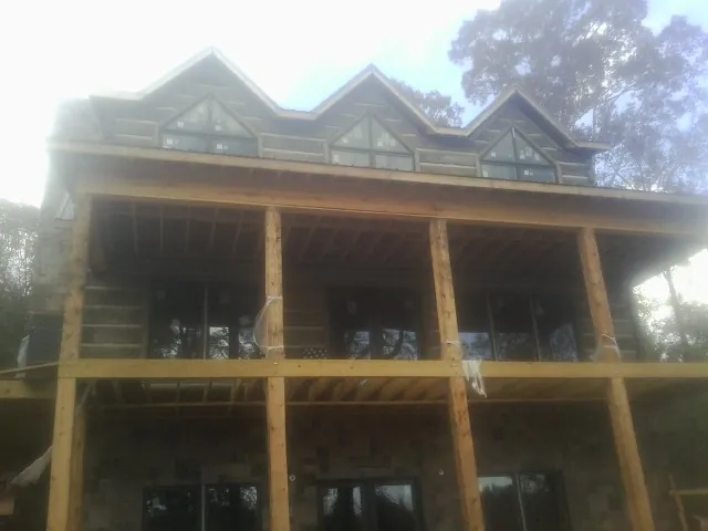 Dormers and porch framing on a large log home under construction — Roof Coating work by our crew in Hollsopple