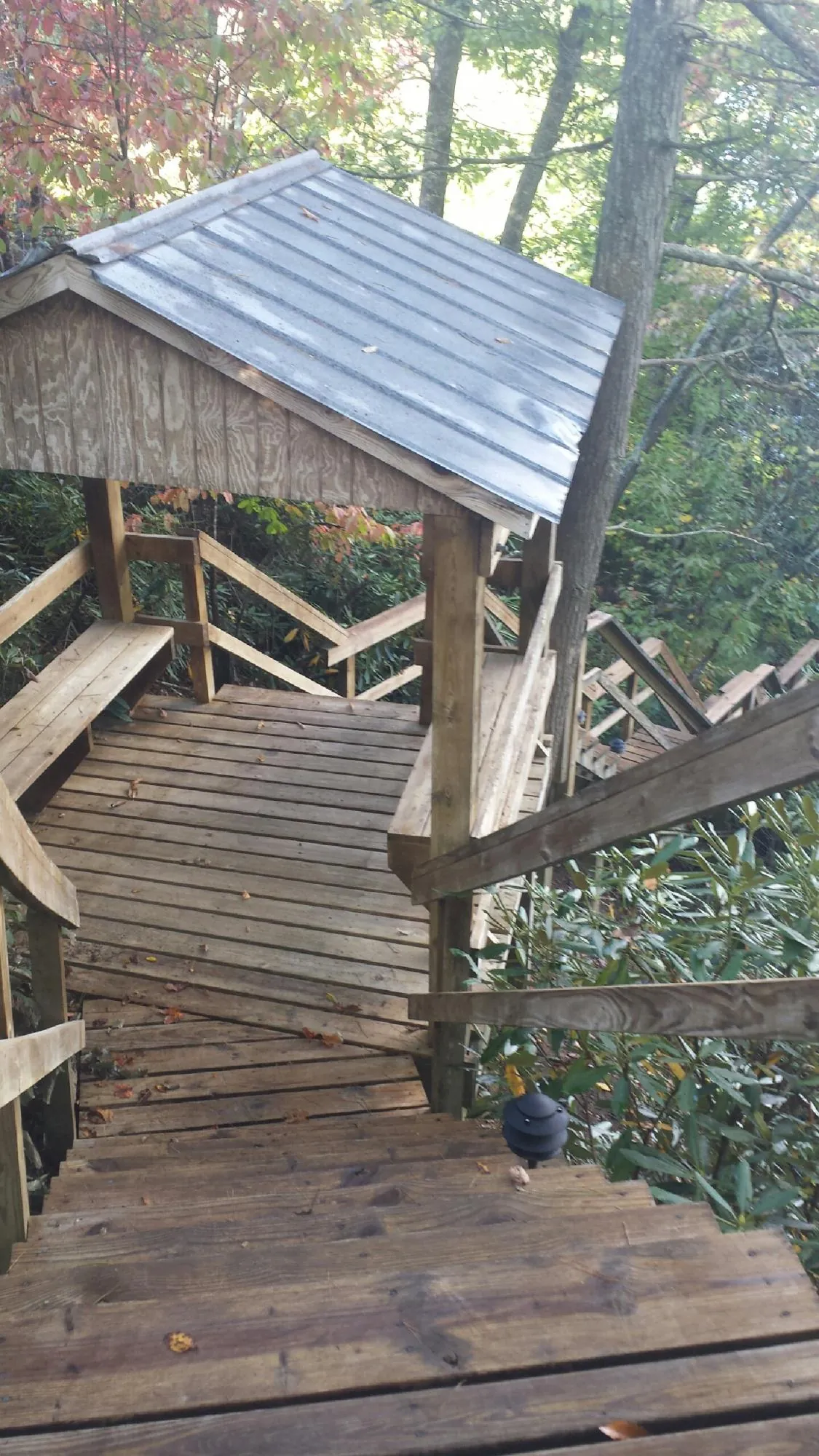 Metal roofed shelter over wooden steps on a wooded walkway — Skylight Repair & Installation work by our crew in Hollsopple
