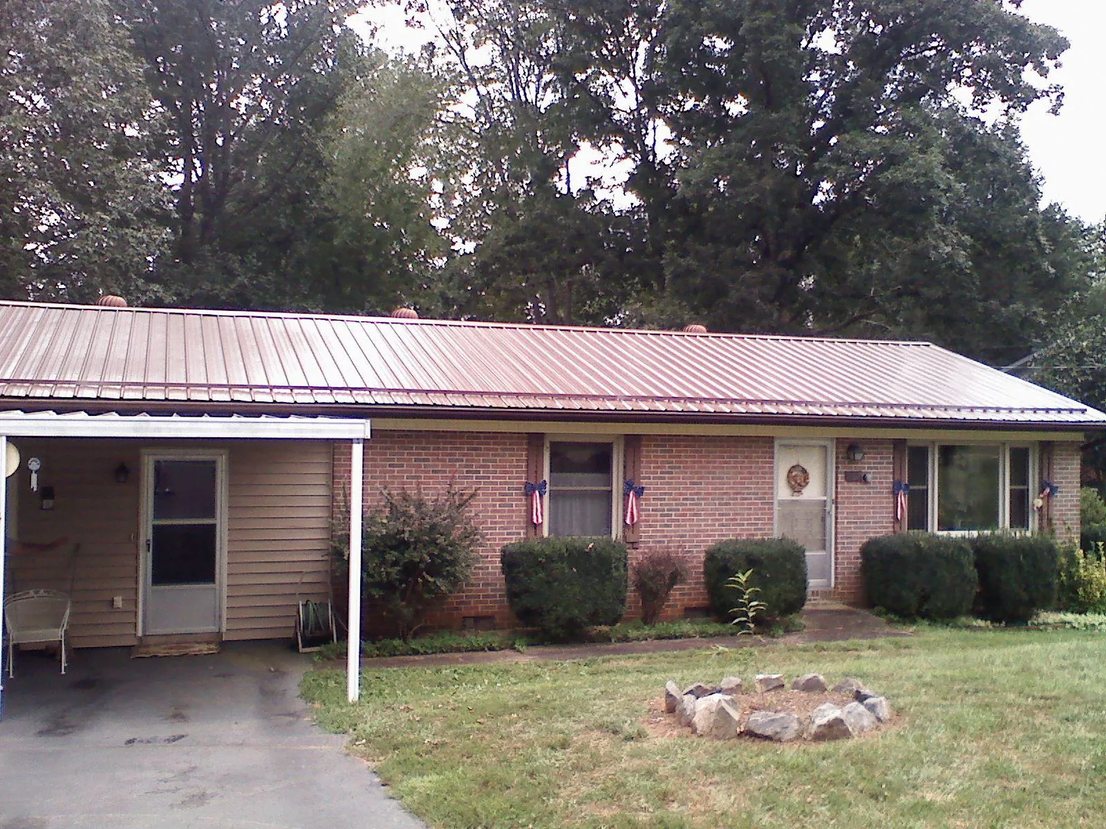 Bronze metal roof and carport on a brick ranch home — Roof Repair work by our crew in Hollsopple